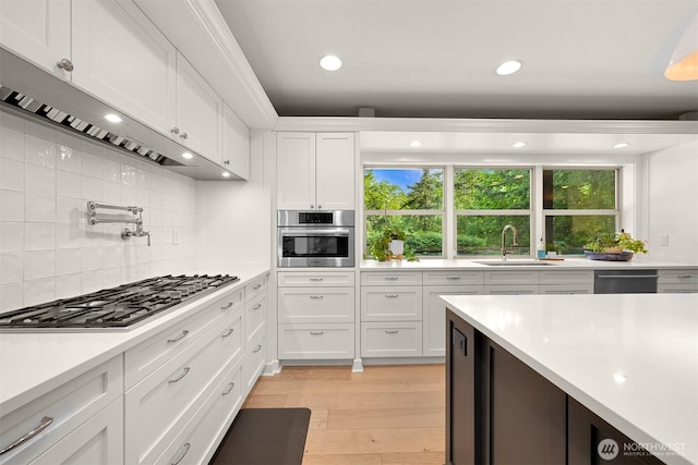 9591 W 34th Cres, Blaine, WA 98230 - kitchen featuring under cabinet range hood, appliances with stainless steel finishes, light countertops, white cabinetry, and backsplash