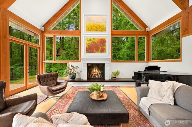 9591 W 34th Cres, Blaine, WA 98230 - living area with a warm lit fireplace, high vaulted ceiling, and wood finished floors