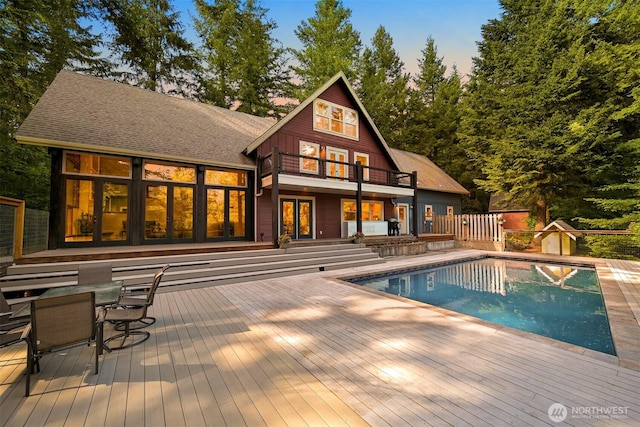 9591 W 34th Cres, Blaine, WA 98230 - rear view of house with a balcony, a deck, an outdoor pool, fence, and a shingled roof