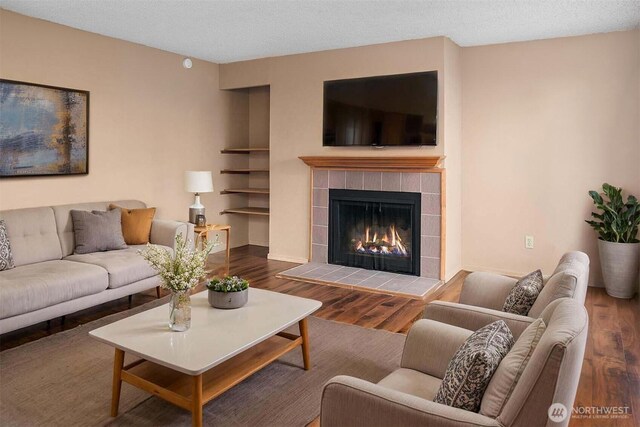 living area with wood finished floors and a tile fireplace