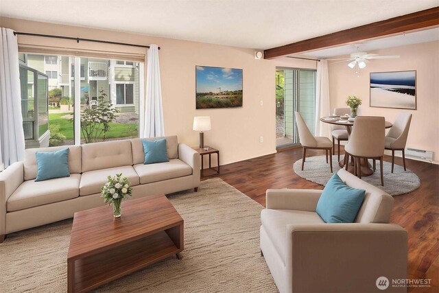 living area with wood finished floors, beam ceiling, and ceiling fan