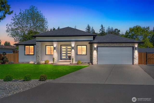 view of front of property with driveway, stone siding, an attached garage, and a shingled roof