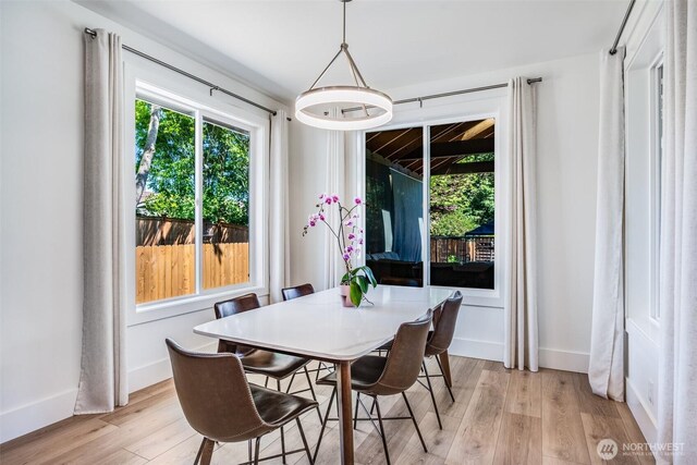 dining area featuring light wood-style floors and baseboards
