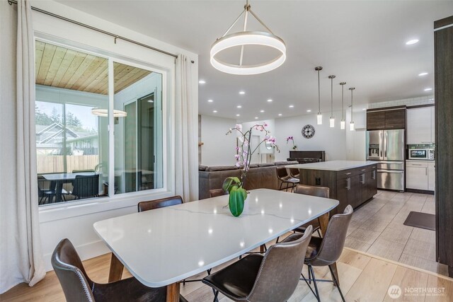 dining space with light wood-type flooring and recessed lighting