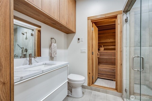 bathroom featuring a shower stall, toilet, vanity, tile patterned floors, and a sauna / steam room
