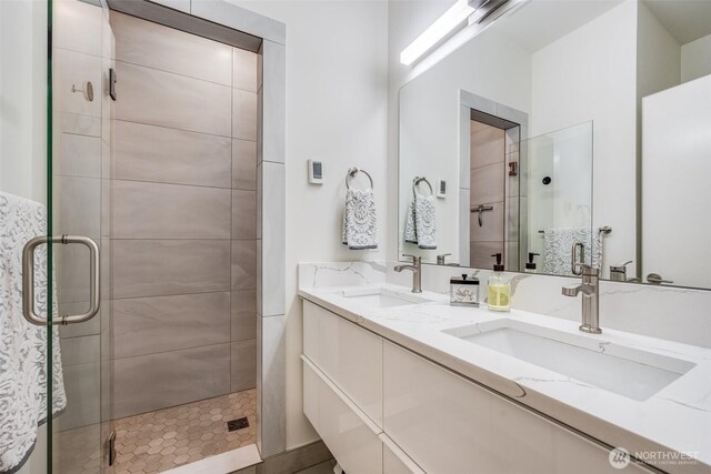 full bathroom featuring a shower stall and double vanity