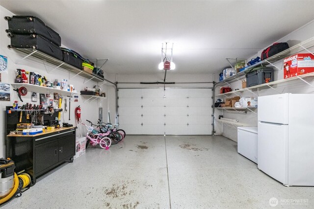 garage featuring freestanding refrigerator, fridge, and a garage door opener
