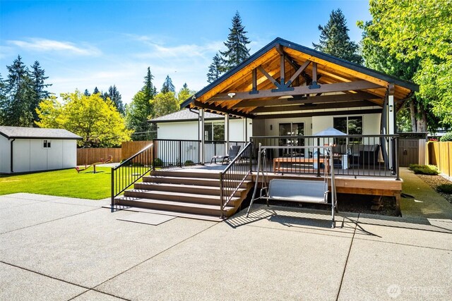 rear view of house featuring a wooden deck, a gazebo, an outdoor structure, and a patio