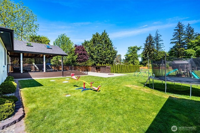 view of yard featuring a trampoline and a playground