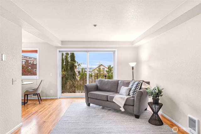 2619 Rucker Ave Unit 4, Everett, WA 98201 - living room featuring light wood-style floors, a textured wall, baseboards, and a textured ceiling