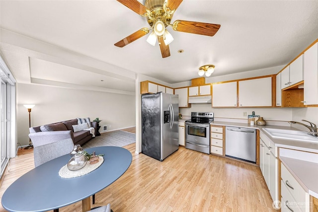 2619 Rucker Ave Unit 4, Everett, WA 98201 - kitchen with stainless steel appliances, a sink, under cabinet range hood, light countertops, and light wood-style floors