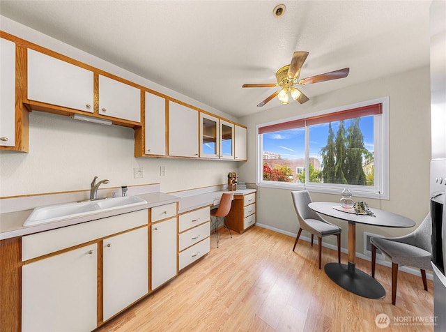 2619 Rucker Ave Unit 4, Everett, WA 98201 - kitchen featuring a sink, a ceiling fan, baseboards, light wood-style flooring, and light countertops