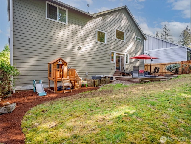 rear view of property with a playground, a wooden deck, and board and batten siding