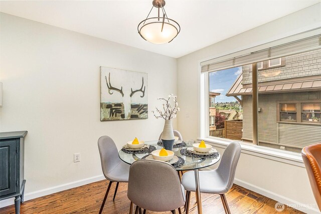 dining room with baseboards and wood finished floors