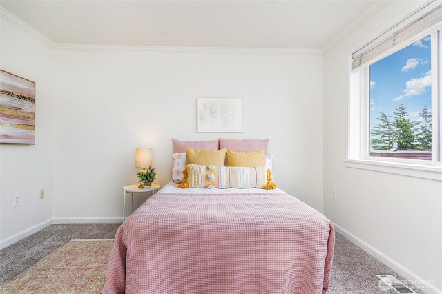 carpeted bedroom with ornamental molding and baseboards