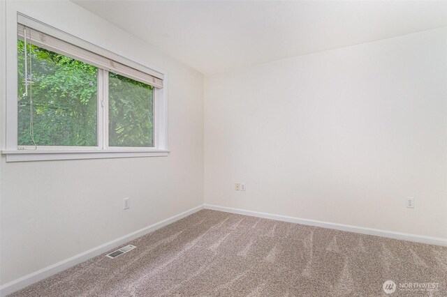 carpeted spare room with baseboards
