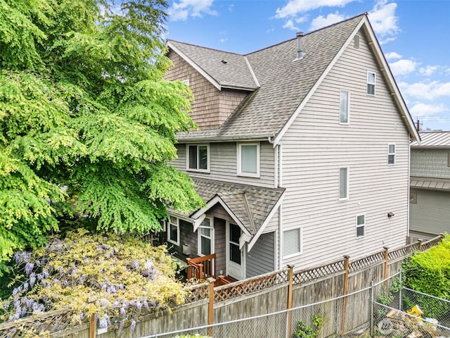 back of property featuring a shingled roof and a fenced backyard