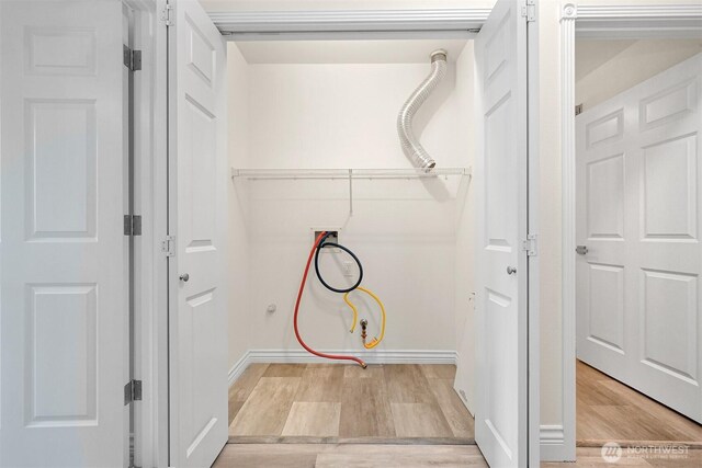washroom featuring light wood-style flooring, washer hookup, and baseboards