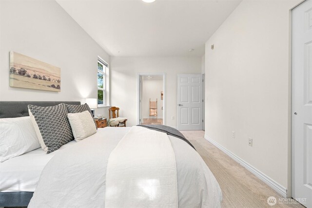 bedroom featuring light carpet and baseboards