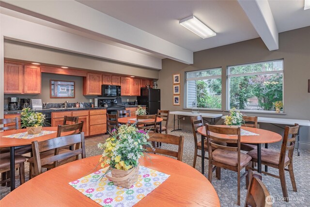 dining area featuring beamed ceiling and baseboards