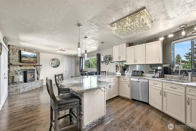 1835 E Smith Rd, Bellingham, WA 98226 - kitchen featuring stainless steel dishwasher, a peninsula, a textured ceiling, a sink, and healthy amount of natural light