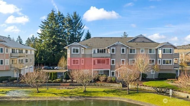 13426 97th Ave E Unit 204, Puyallup, WA 98373 - rear view of property with a water view and a lawn