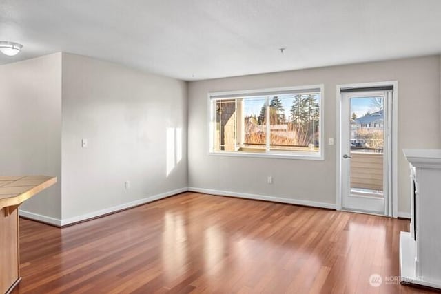 13426 97th Ave E Unit 204, Puyallup, WA 98373 - unfurnished living room featuring wood finished floors and baseboards