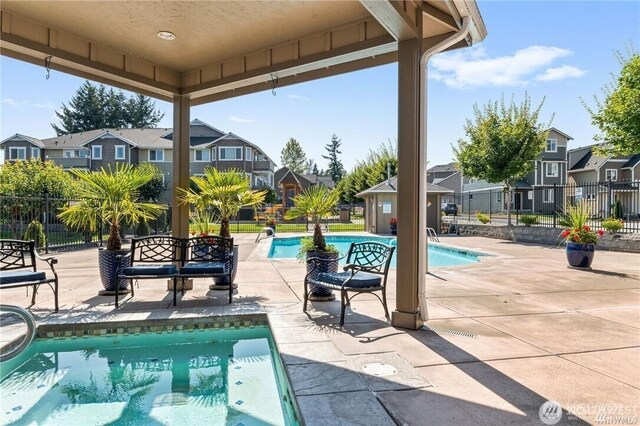 13426 97th Ave E Unit 204, Puyallup, WA 98373 - view of swimming pool with a residential view, a patio, and fence