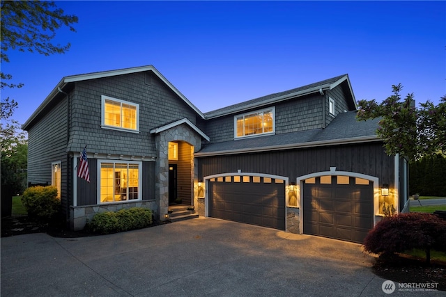 view of front facade featuring concrete driveway, stone siding, and a shingled roof