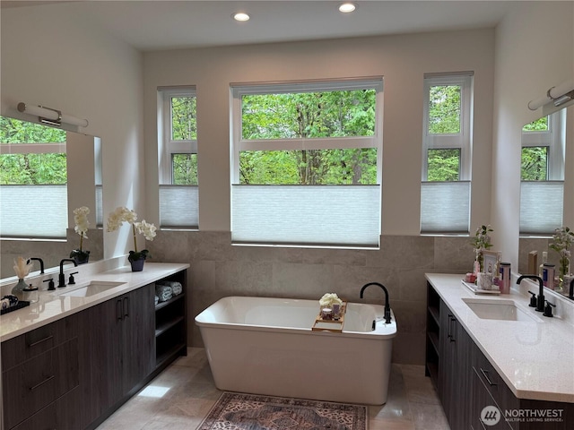 25117 235th Ct SE, Maple Valley, WA 98038 - bathroom featuring plenty of natural light, tile walls, a soaking tub, two vanities, and recessed lighting