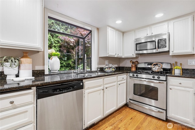 21016 NE 33rd Pl, Sammamish, WA 98074 - kitchen with stainless steel appliances, a sink, white cabinetry, light wood-style floors, and dark stone countertops