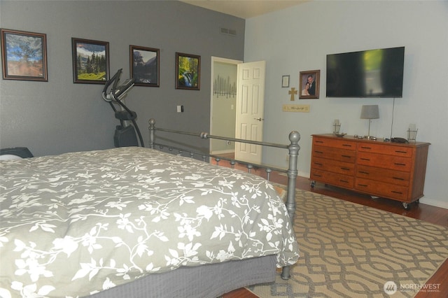bedroom with wood finished floors and baseboards