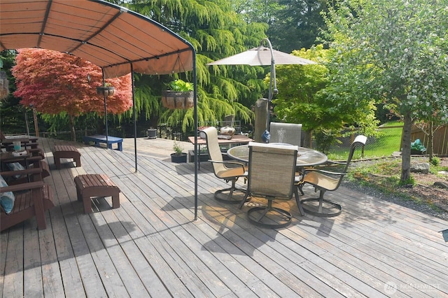wooden terrace featuring fence and outdoor dining area