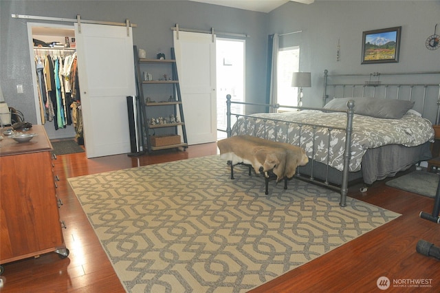 332 Rhododendron Dr, Sequim, WA 98382 - bedroom with a barn door, wood finished floors, a spacious closet, and a closet