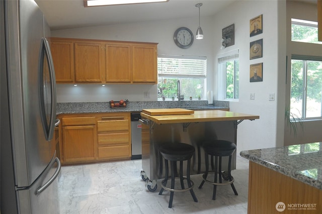 332 Rhododendron Dr, Sequim, WA 98382 - kitchen with freestanding refrigerator, light marble finish flooring, a breakfast bar area, vaulted ceiling, and brown cabinets