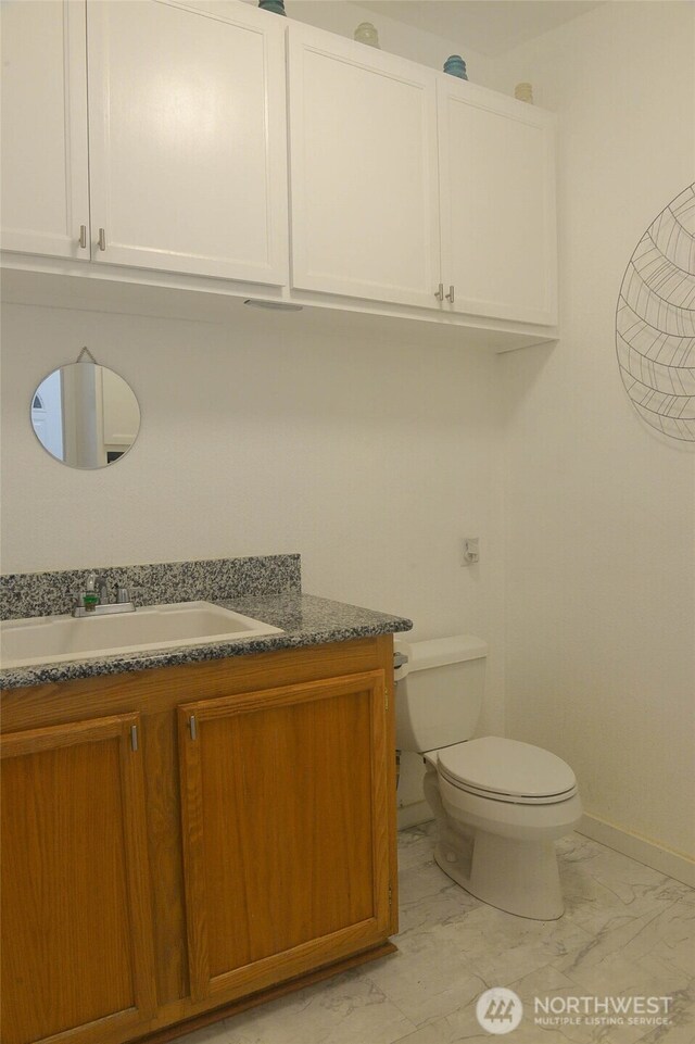 332 Rhododendron Dr, Sequim, WA 98382 - half bathroom with marble look tile flooring, toilet, vanity, and baseboards
