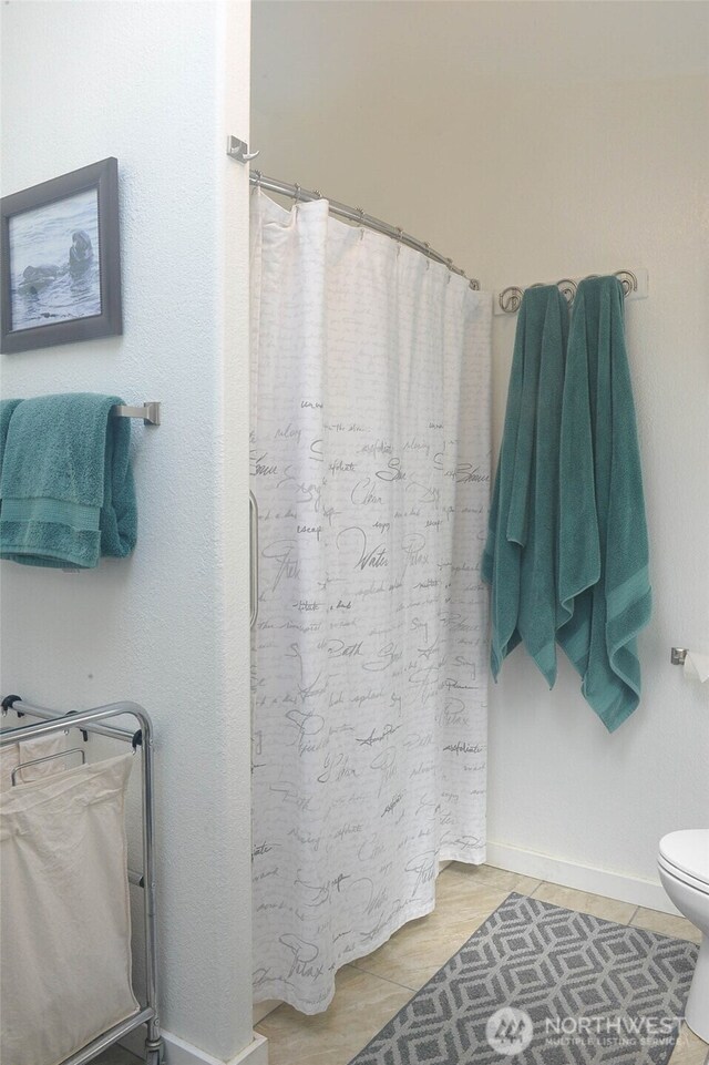 332 Rhododendron Dr, Sequim, WA 98382 - full bath featuring a shower with curtain, toilet, baseboards, and tile patterned flooring