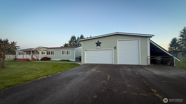 view of front of home featuring asphalt driveway and a front lawn