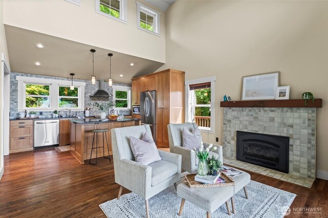 1533 S Sunset Dr, Tacoma, WA 98465 - living room featuring dark wood finished floors, a fireplace with flush hearth, a towering ceiling, and recessed lighting