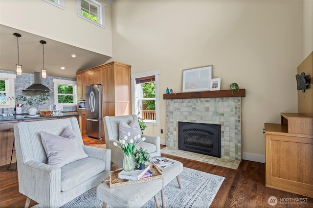 1533 S Sunset Dr, Tacoma, WA 98465 - living room with a fireplace with flush hearth, wood finished floors, a high ceiling, and baseboards