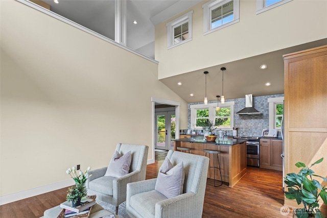 1533 S Sunset Dr, Tacoma, WA 98465 - kitchen with electric range, wall chimney exhaust hood, dark countertops, a kitchen breakfast bar, and dark wood finished floors