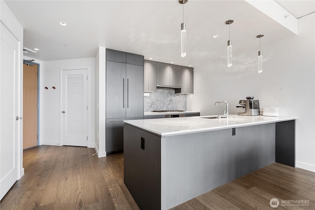 kitchen featuring gray cabinets, a peninsula, modern cabinets, dark wood-type flooring, and recessed lighting