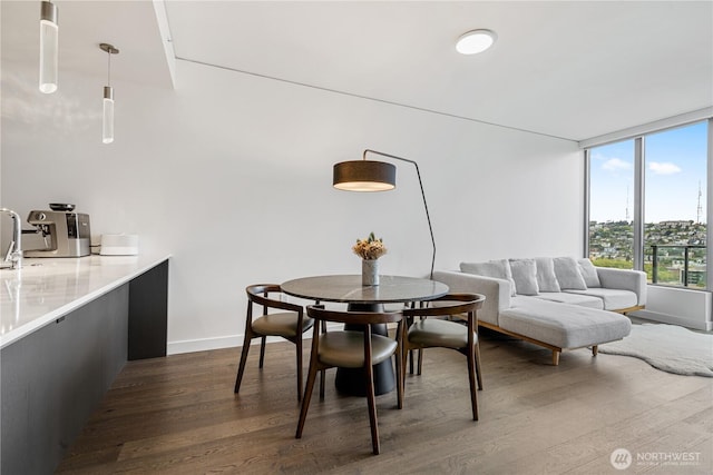 dining space featuring dark wood-style flooring and baseboards