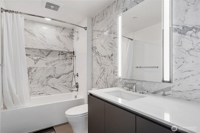 bathroom with shower / bath combination with curtain, tile walls, toilet, and vanity