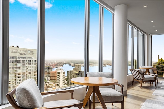 dining area featuring a water view, a city view, recessed lighting, and expansive windows
