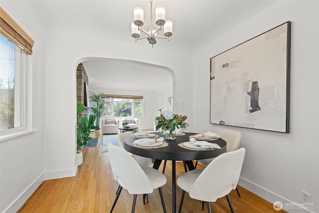3112 13th Ave S, Seattle, WA 98144 - dining area with arched walkways, baseboards, light wood-style floors, and a chandelier