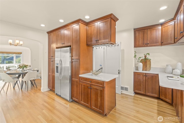 3112 13th Ave S, Seattle, WA 98144 - kitchen with stainless steel refrigerator with ice dispenser, light wood-style floors, brown cabinetry, light countertops, and recessed lighting