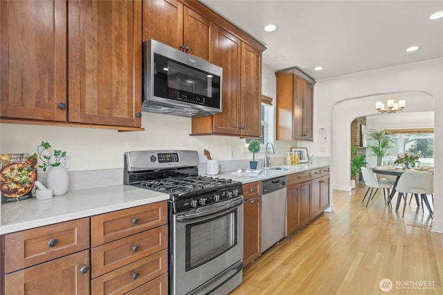 3112 13th Ave S, Seattle, WA 98144 - kitchen with appliances with stainless steel finishes, light wood-style floors, a chandelier, light countertops, and recessed lighting