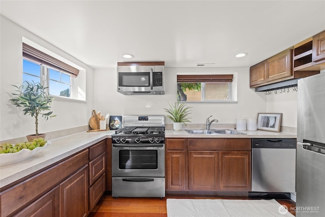3112 13th Ave S, Seattle, WA 98144 - kitchen featuring appliances with stainless steel finishes, a sink, light countertops, brown cabinetry, and recessed lighting