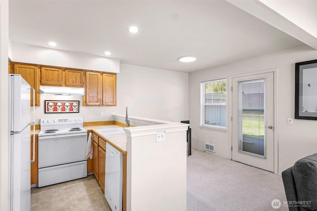 kitchen featuring white appliances, under cabinet range hood, a peninsula, recessed lighting, and light countertops